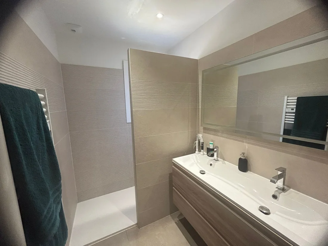 Salle de bain rénovée avec douche et double vasque