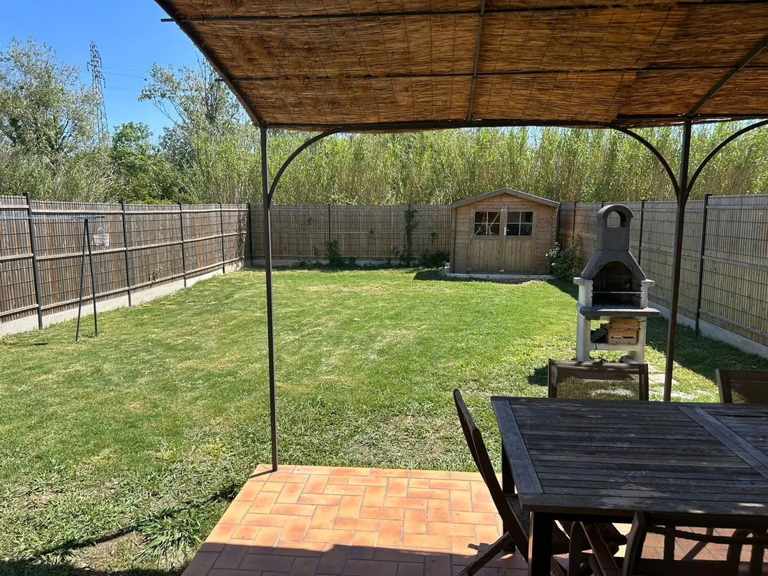 Terrasse ombragée donnant sur le jardin, abri de jardin et barbecue
